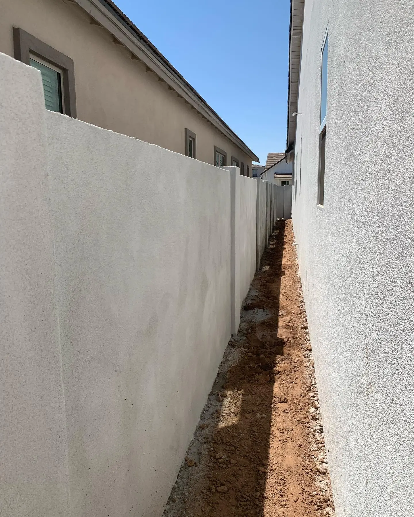 Smooth-finished masonry block privacy wall between two homes
