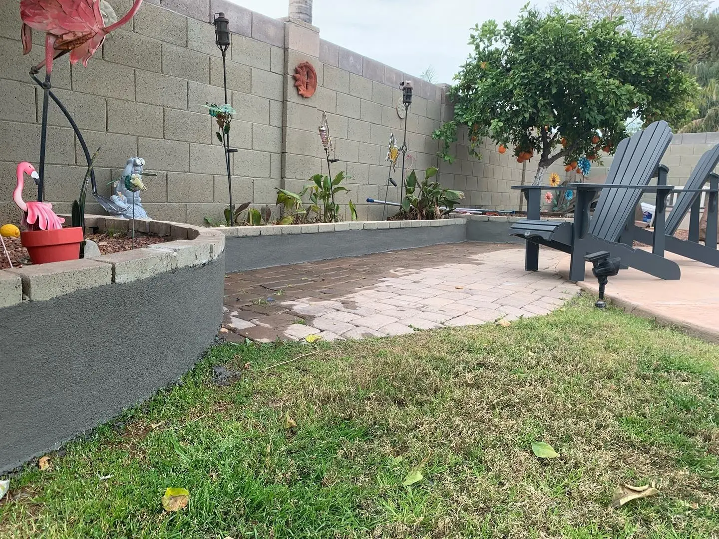Finished backyard with paver patio and freshly coated block planter